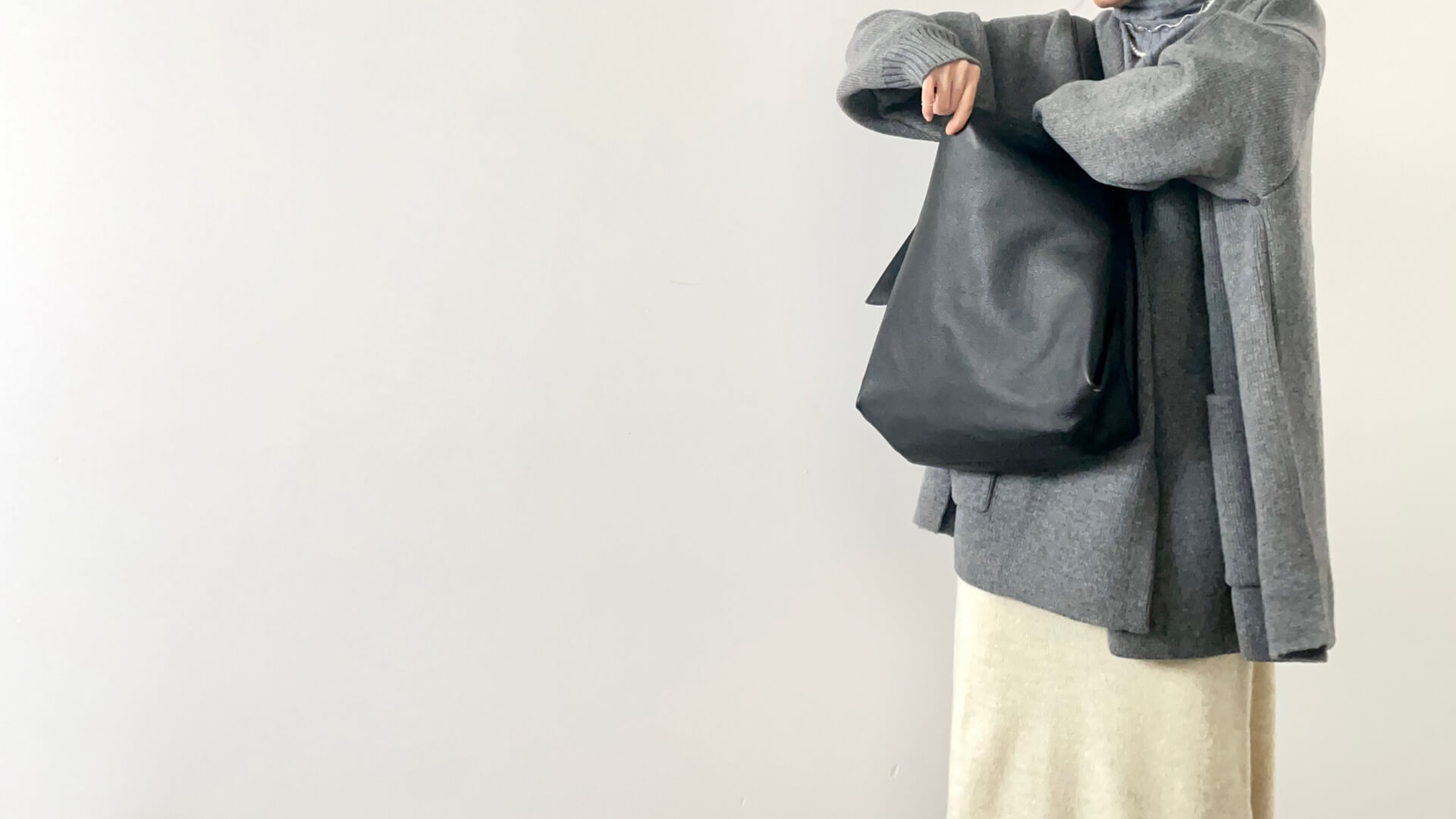 灰色のバッグとシンプルな装い